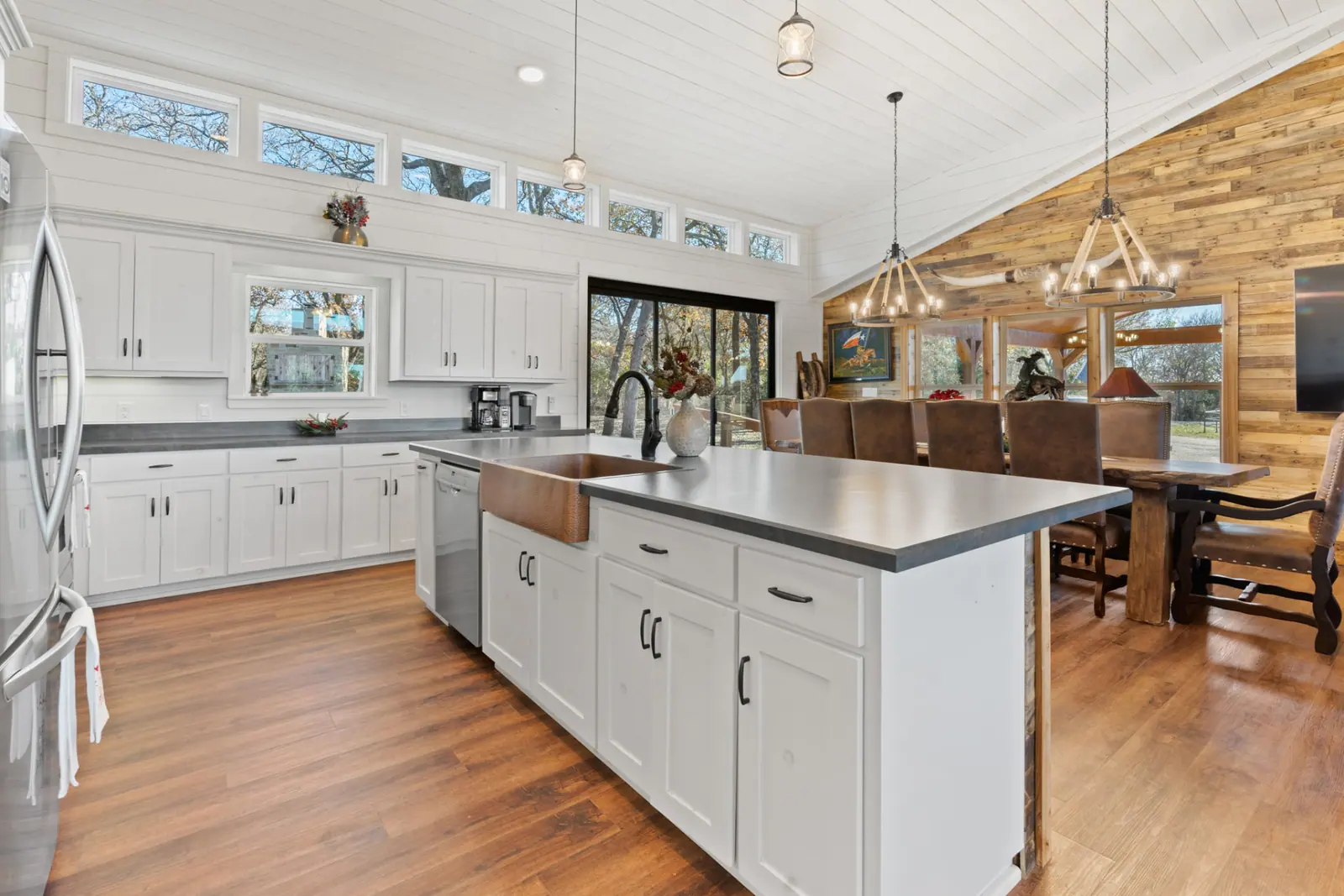 Open kitchen with copper farmhouse sink, quartz island and reclaimed wood accent wall