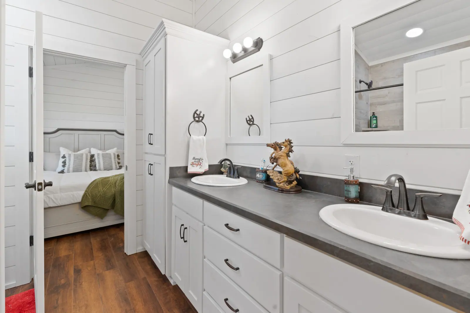 Dual-vanity bath with concrete-look counters opening to a bedroom
