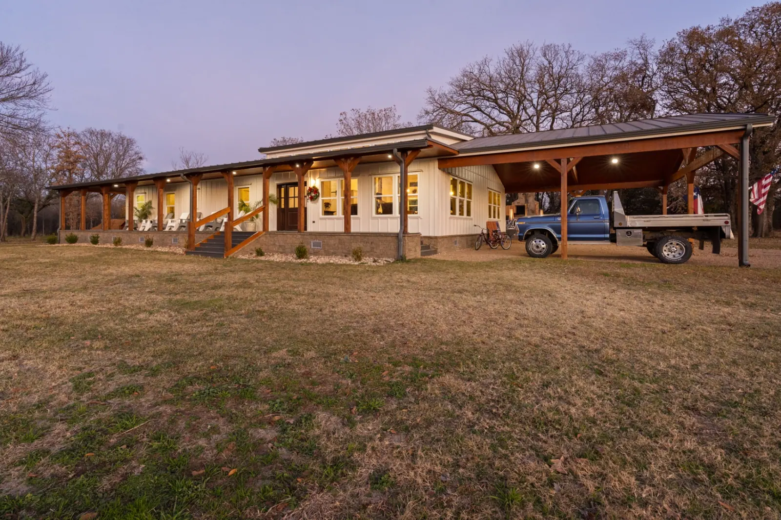 Luxury Ranch Home at dusk with covered porch and carport