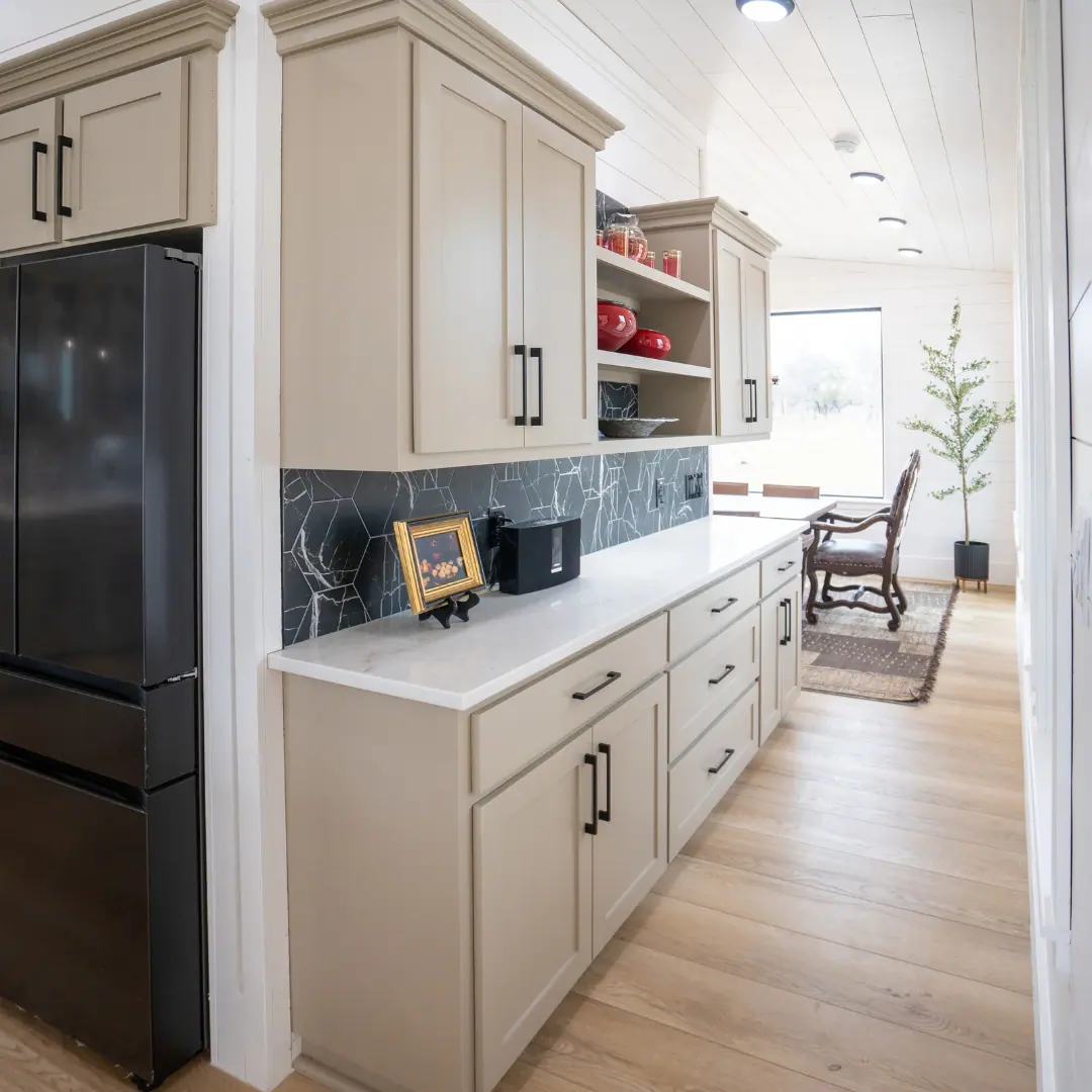 Butler pantry with quartz counters and marble backsplash