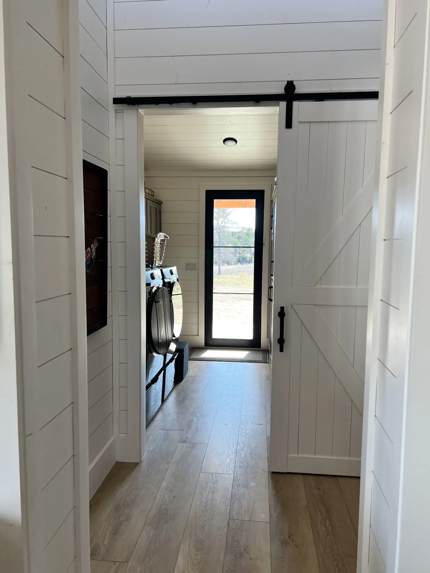 Hallway with sliding barn door leading to the laundry room
