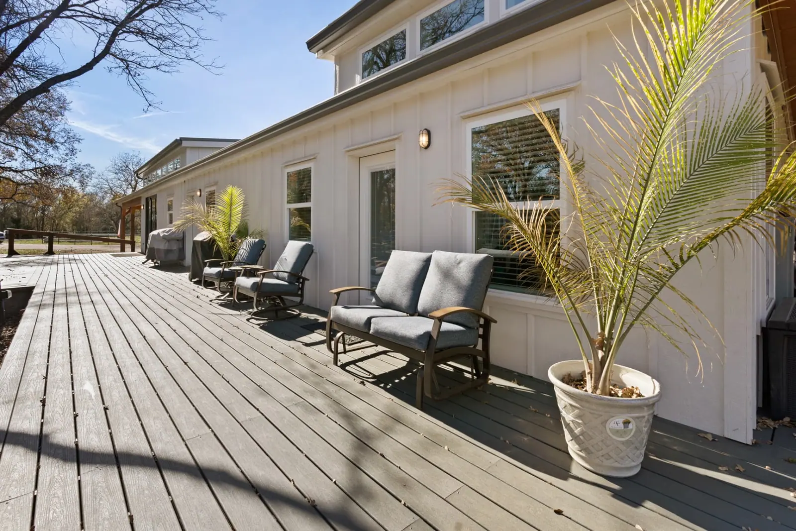 Side deck with glider seating and potted palms