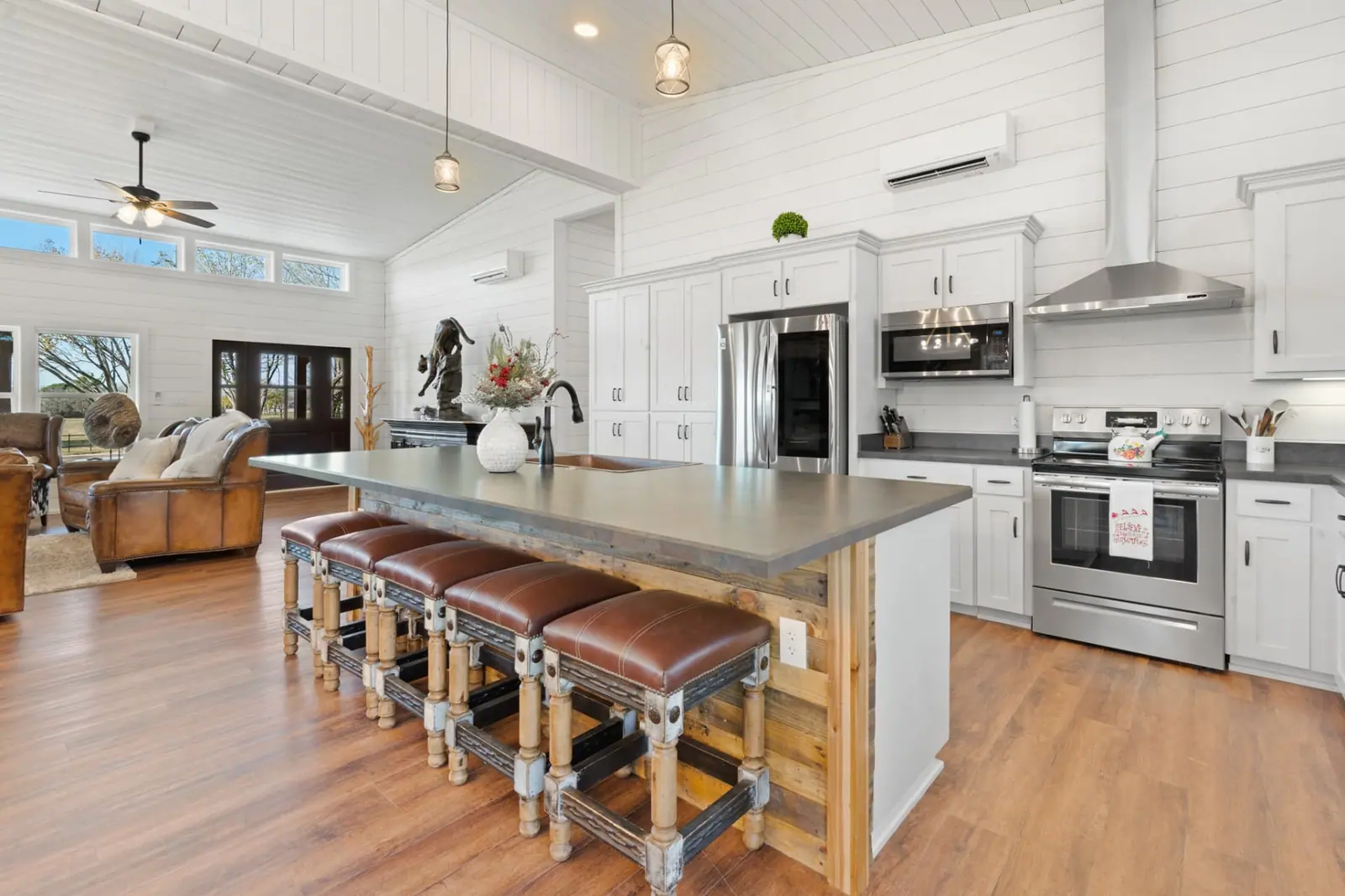 Kitchen island with concrete countertop and leather barstools