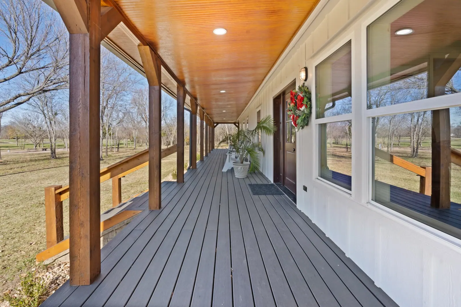 Covered front porch with timber posts and stained wood ceiling