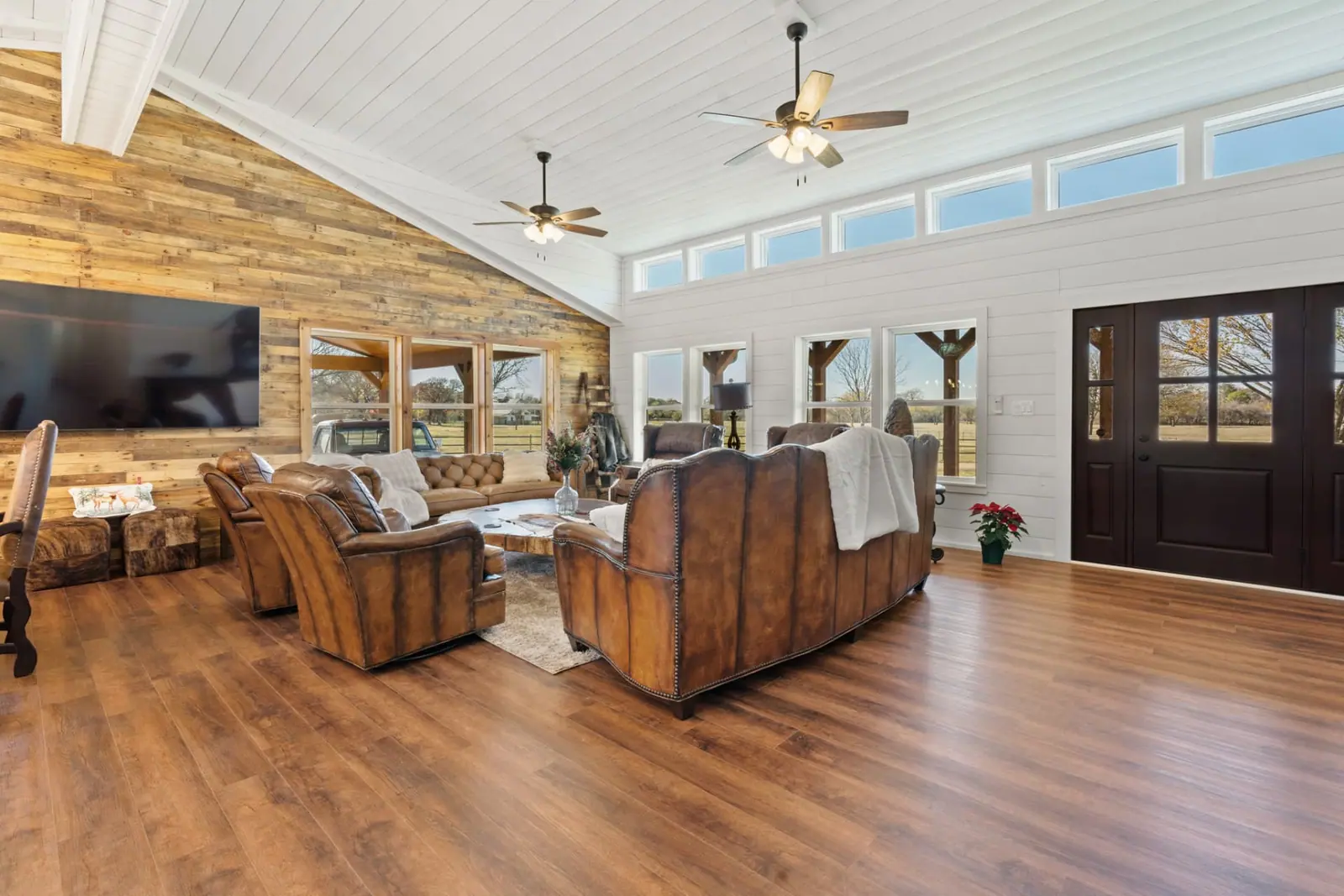 Great room with leather seating, reclaimed wood accent wall and vaulted ceiling