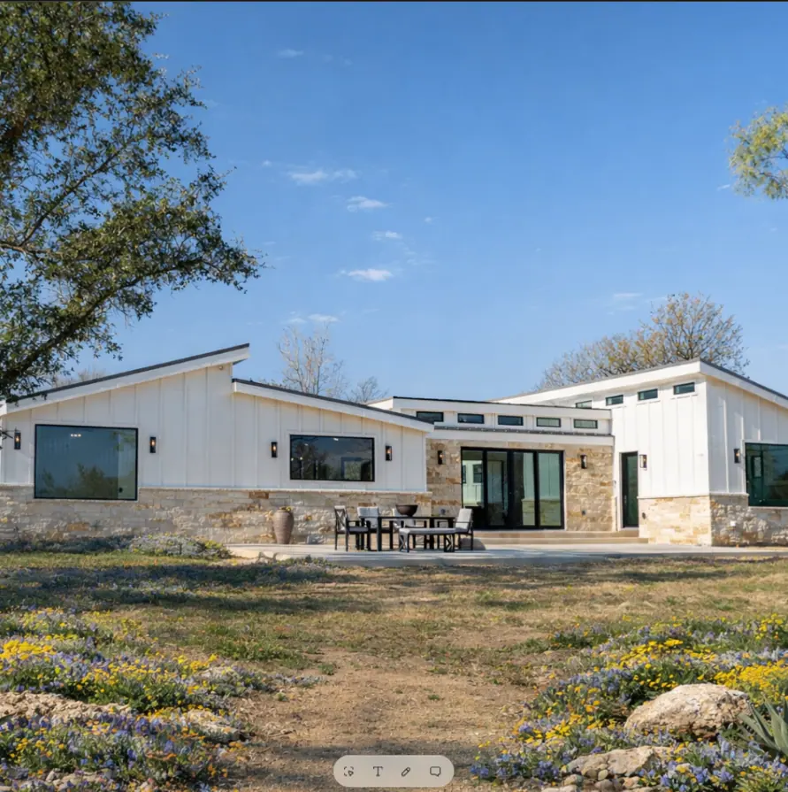 Luxury Ranch Home exterior with white board-and-batten siding, stone accents, and outdoor dining patio