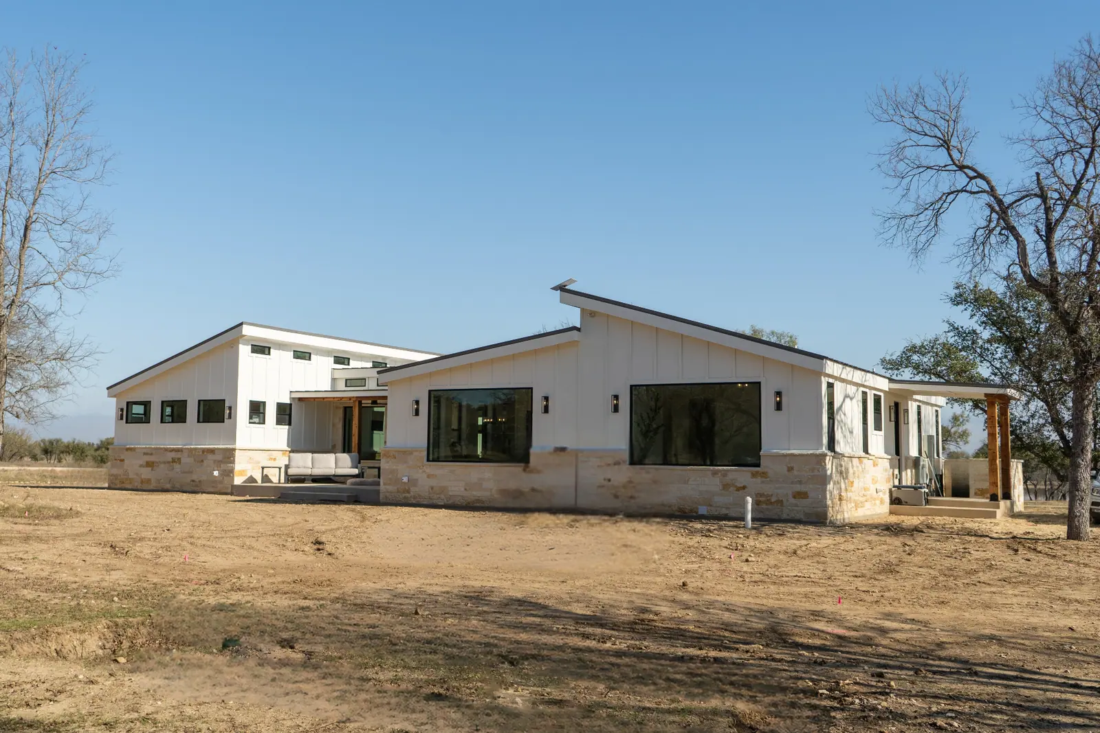 Modern ranch exterior with shed rooflines, limestone base and board-and-batten siding